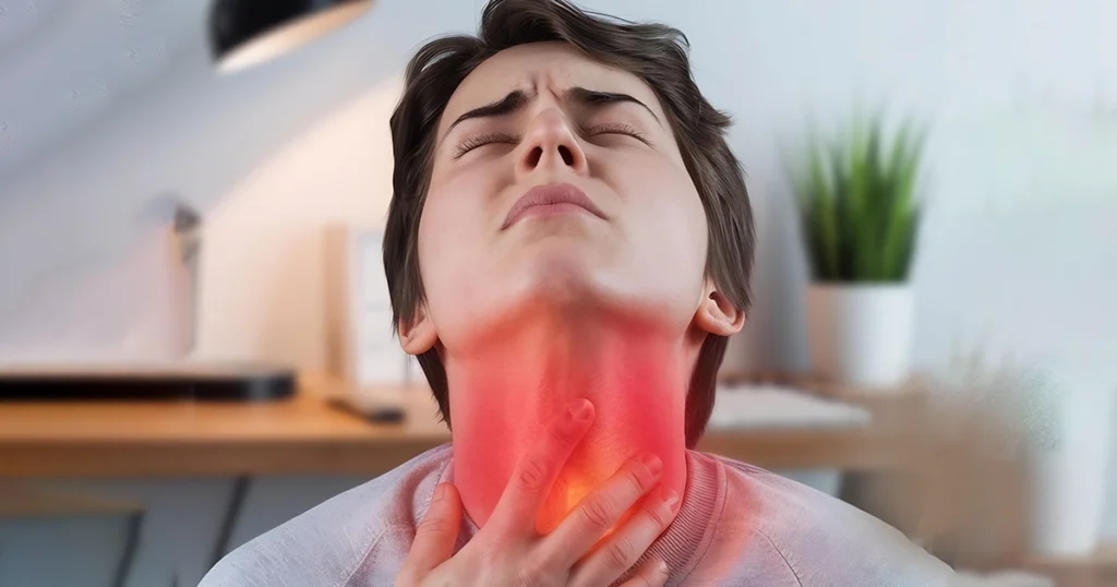Person holding throat with visible redness, showing sore throat pain.