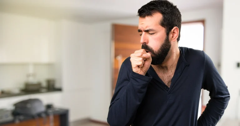 Person coughing in indoor setting.