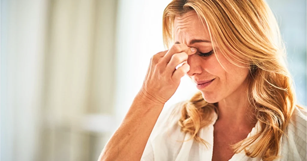 Person rubbing eyes from brain fog.